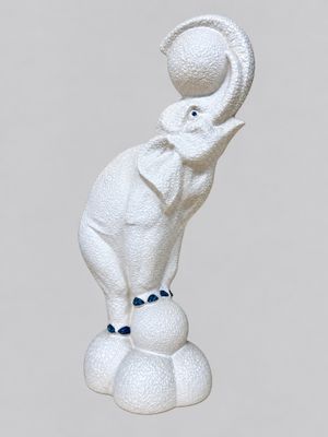 statue of an elephant balancing a ball on its trunk