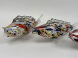 three glass fish figurines sitting on a white surface