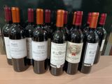 plusieurs bouteilles de vin rouge sont alignées sur une table