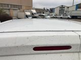 a white car parked in a parking lot with other cars in the background