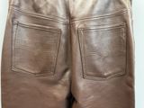 the back of a pair of brown leather pants on a hanger