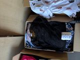 several pairs of underwear are in a cardboard box on the floor