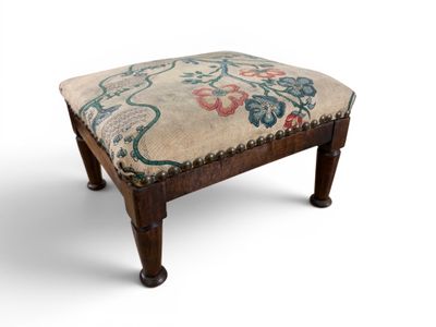 un repose-pieds rembourré orné d'un motif floral