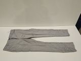 un pantalon gris posé sur une table blanche