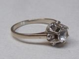 une image d'une bague en diamant sur une surface blanche