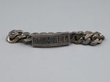 un gros plan d'un bracelet en métal entouré d'une chaîne