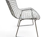 a black wire chair sitting on top of a metal frame