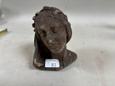 une petite statue représentant une femme, sur laquelle est apposée une étiquette avec son nom