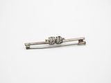 a close up of a silver tie bar on a white surface