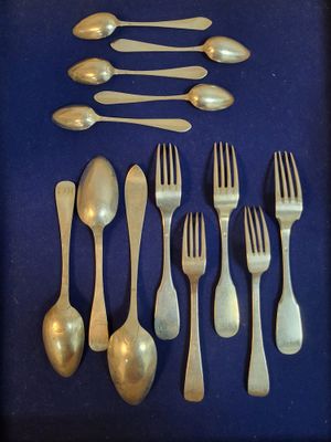 de nombreuses cuillères et fourchettes en argent sur un fond bleu