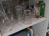 many empty wine glasses and bottles on a shelf
