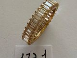 an image of a gold ring with baguets on a white surface