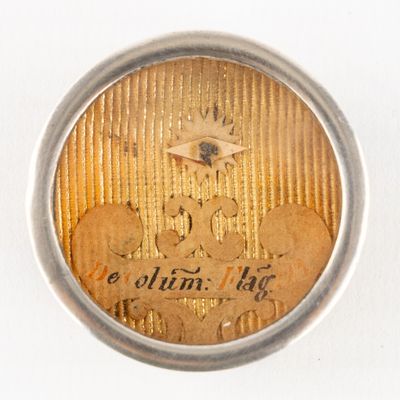 a close up of a gold coin in a silver case