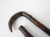 pair of antique wooden handled canes on a white surface