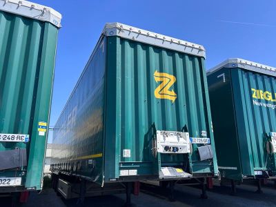 deux gros camions de livraison verts garés l'un à côté de l'autre sur un parking