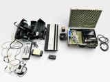 une valise contenant un appareil photo et d'autres appareils électroniques, posée sur une surface blanche