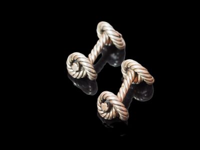 two pieces of silver colored rope on a black surface