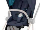 une poussette avec un siège bleu et un guidon blanc
