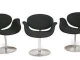 trois chaises noires placées les unes à côté des autres sur une surface blanche