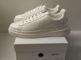 les baskets blanches sont posées sur une boîte blanche