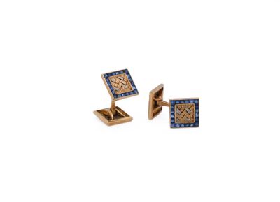 two gold cufflinks with blue and white diamonds on them