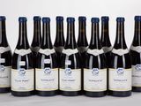 six bottles of wine are lined up in a row on a white surface