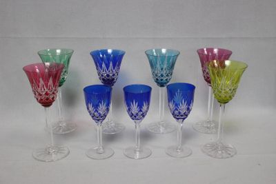 plusieurs verres à vin de couleurs différentes sont alignés sur une surface blanche