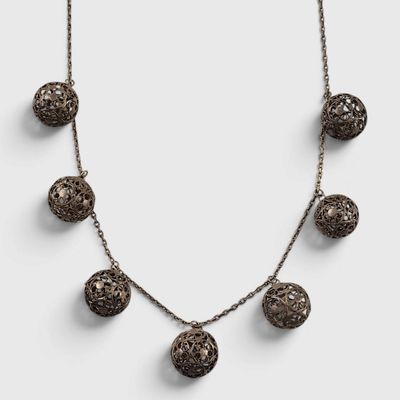 a close up of a necklace on a white surface