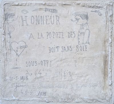 a stone plaque on the side of a building with writing on it