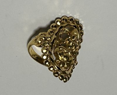 gros plan d'une bague en or sur une surface blanche