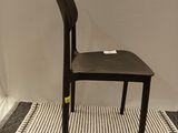 a black chair sitting on a striped rug in a room