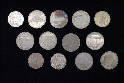 un grand nombre de pièces de monnaie qui se trouvent sur une surface noire