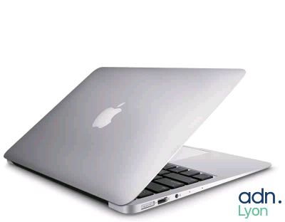 un ordinateur portable Apple blanc posé sur une table blanche