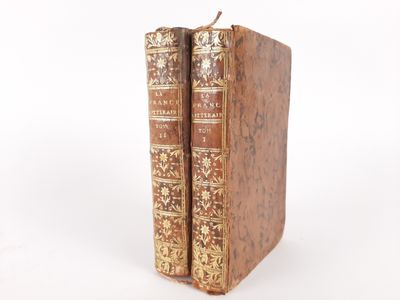an old pair of books sitting on top of each other on a white surface