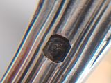 a piece of metal with a coin on it on a fork