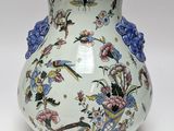 a white vase with blue and pink flowers on it