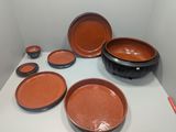 many brown and black bowls and plates on a white table