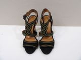 a pair of black and yellow heels on a white surface
