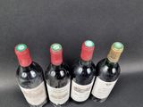 four bottles of wine are lined up on a black surface