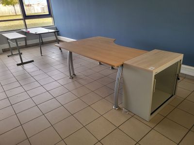 a desk with a microwave on it in the corner of a room
