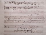an old manuscript with music notes on it and a pen