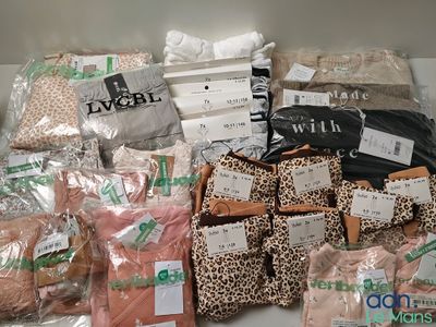 de nombreux sacs contenant des vêtements et d'autres objets, posés sur une étagère