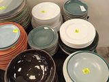 a lot of plates and bowls on the table