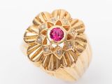 une image d'une bague en or avec une pierre rose au centre