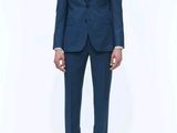 un homme en costume bleu et cravate noire