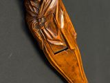 sculpture sur bois représentant un homme dans un bateau, sur un fond noir