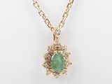 a close up of a necklace with a green stone on a chain