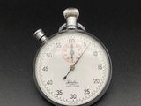 a close up of a stopwatch on a black surface