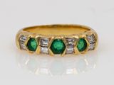 a close up of a gold ring with emeralds and diamonds