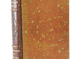 an old book sitting on top of a white surface next to a white background